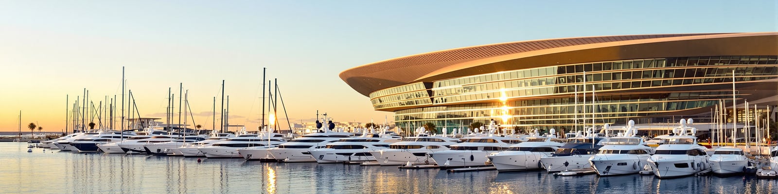 La Marina de Valencia with superyacht berths at golden hour, yacht wine delivery by Onshore Cellars