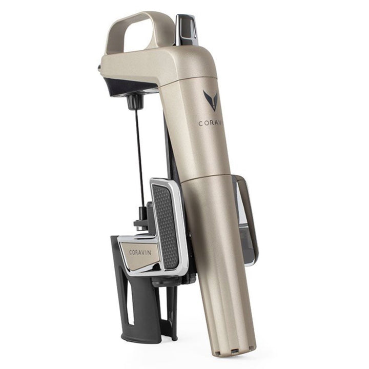 Un CORAVIN™ Model Two Elite Plus Pack, que presenta un elegante diseño en dorado y negro con un mecanismo en forma de aguja para verter el vino sin quitar el corcho. Se presenta sobre un fondo blanco liso.