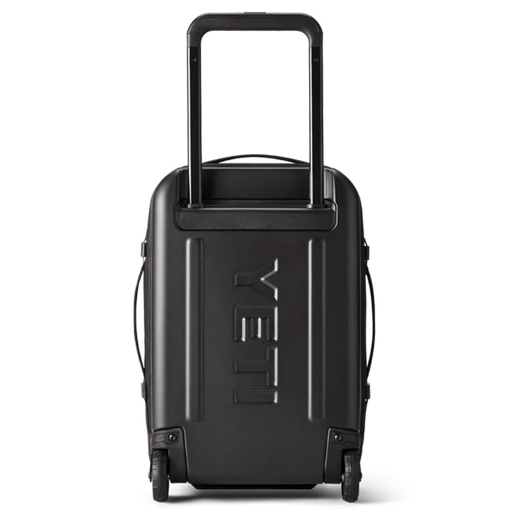 A Yeti - Crossroads - Luggage 22, featuring a black hard-shell design with wheels and an extended telescopic handle, has the brand name "YETI" embossed on its front. The suitcase includes side handles and is displayed against a white background.