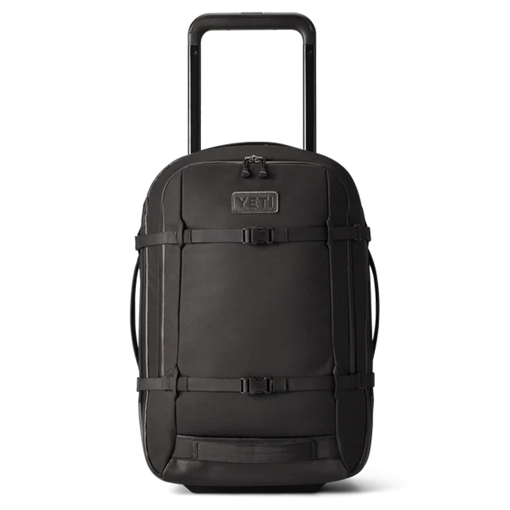 A black Yeti Crossroads Luggage 22 with a sturdy handle and multiple buckles. The front showcases an embossed YETI logo. Its sleek, streamlined design includes side handles for easy carrying.