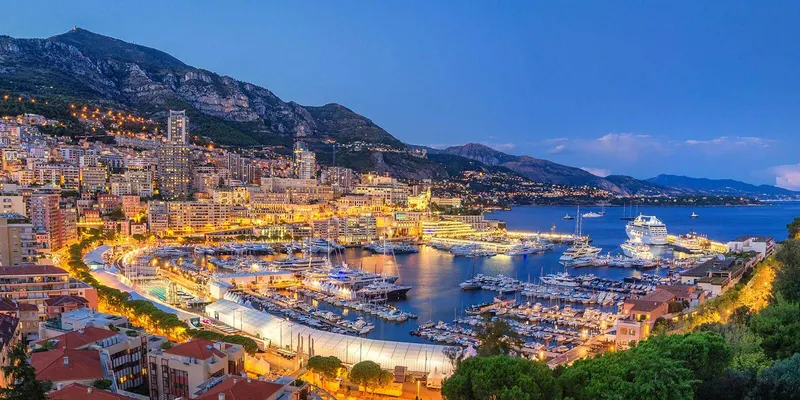 A panoramic view of Monaco at dusk with the marina full of yachts
